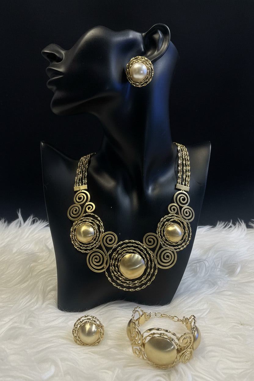 Gold Bentix Brazilian Round jewelry set displayed on white fur surface, featuring earrings and necklace with intricate design.