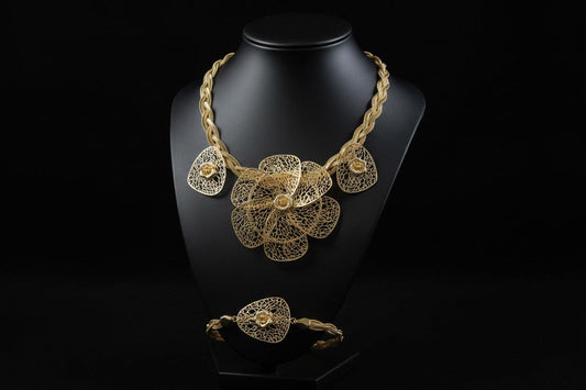 Gold floral jewelry set including bracelet, ring, and earrings by BENTIX featuring intricate plaited design and Brazilian gold accents.